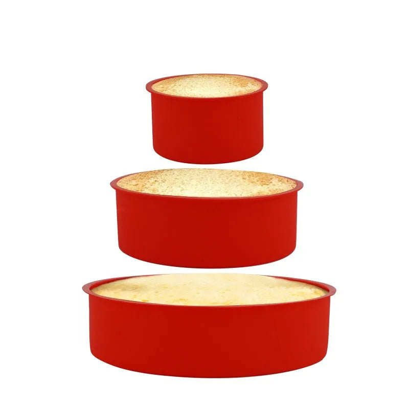 Set of three round red silicone cake moulds in 4-inch, 6-inch, and 8-inch sizes on a baking tray.