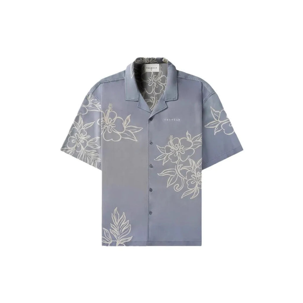 A man modelling a loose-fitting, short-sleeved beige cardigan with a printed floral pattern.