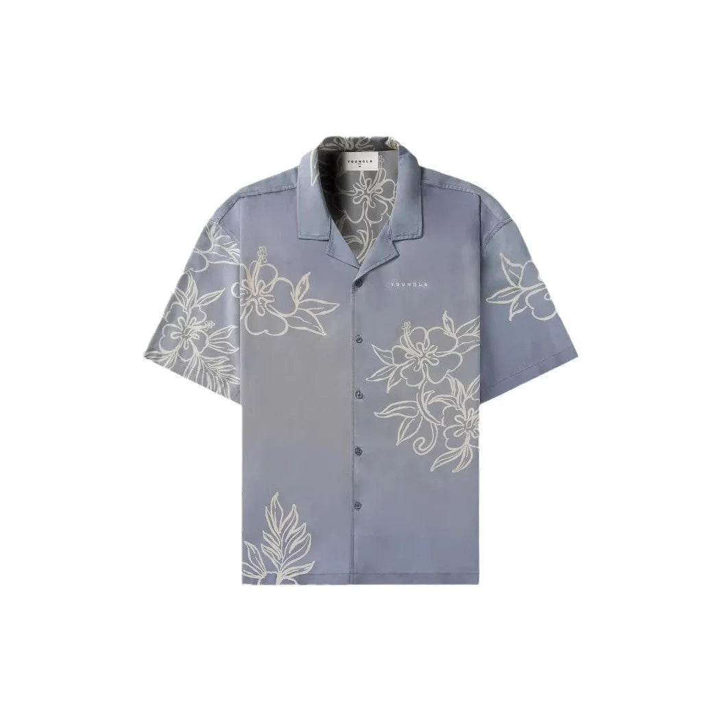 A man modelling a loose-fitting, short-sleeved beige cardigan with a printed floral pattern.