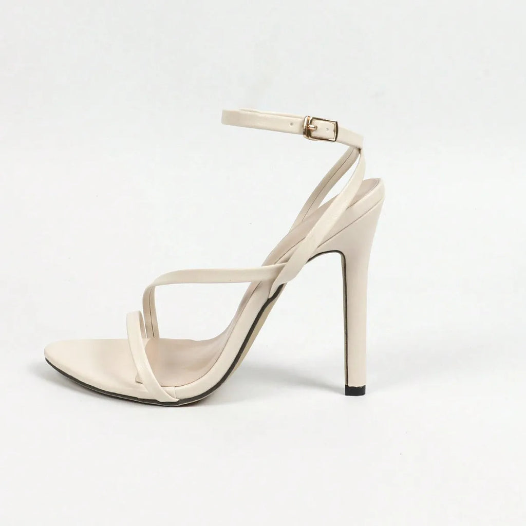 Gold women's high heel sandals with open toe and crossed ankle straps on a white background.