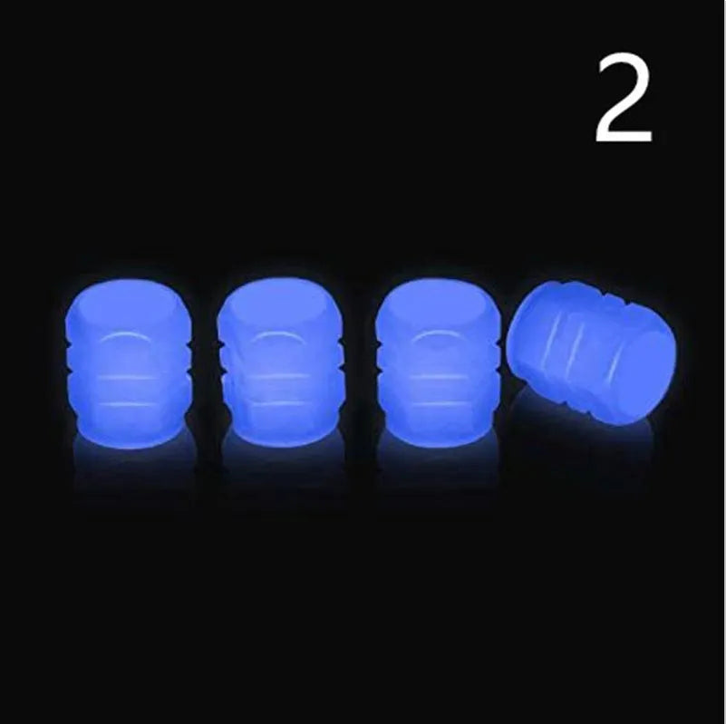 Set of luminous green and blue rubber tyre valve caps on a tyre valve stem.