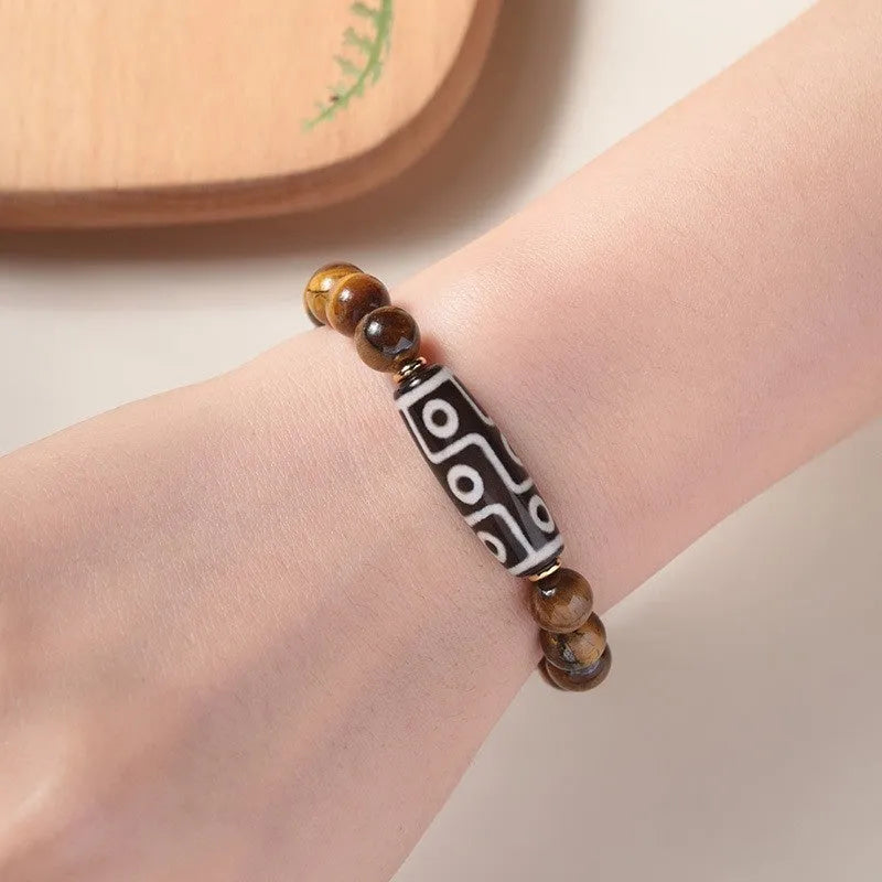 Single tigereye bead ethnic Buddha bracelet on wrist, showing simple rosary style.
