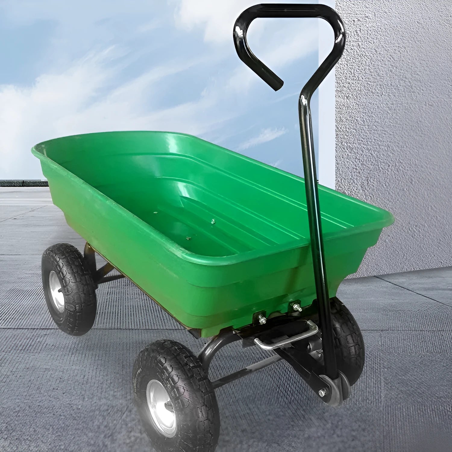 Green TC2145 four-wheel toy dump truck with steel frame and plastic body in a garden setting.