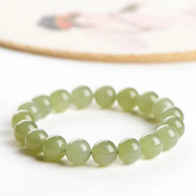 Polished Hetian jade bead bracelet in ice-like clear tones on a white background.