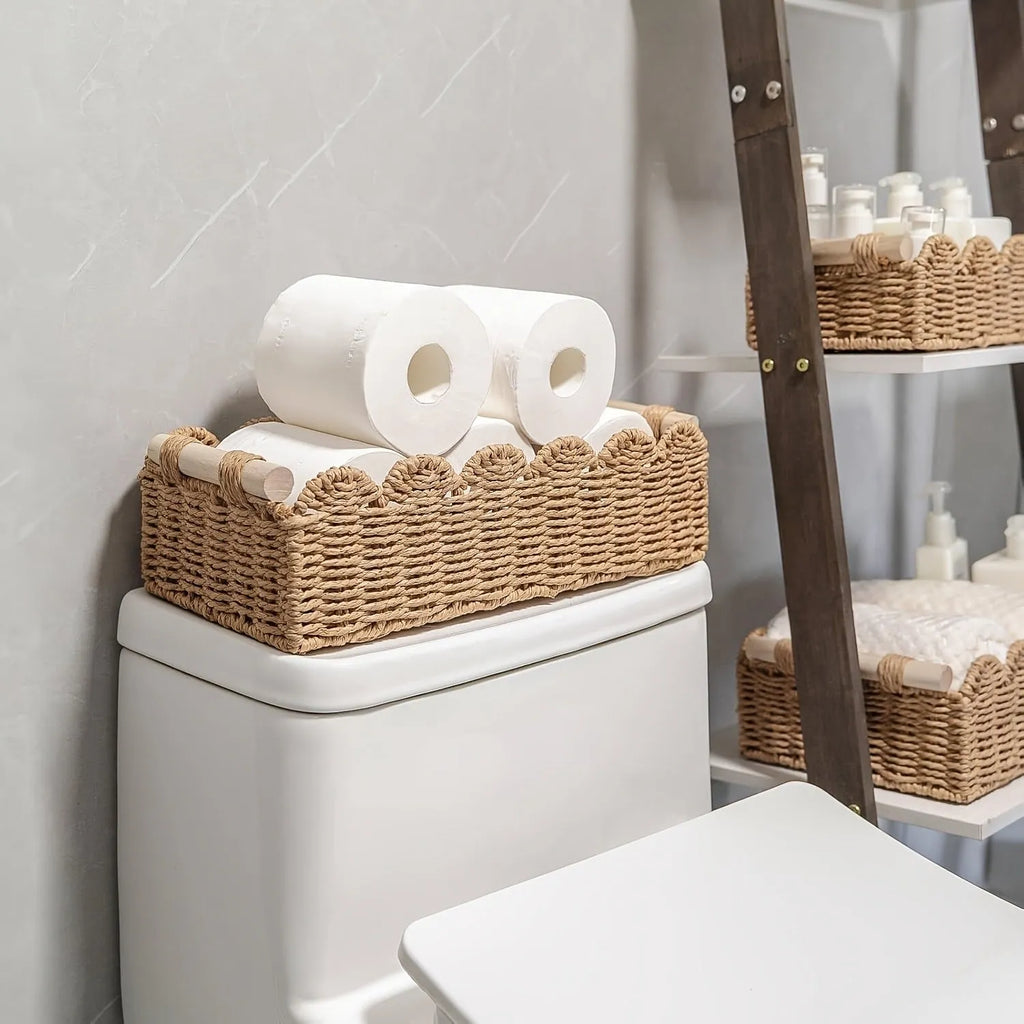 Woven paper storage basket in khaki colour on a desktop holding remote controls and pens.