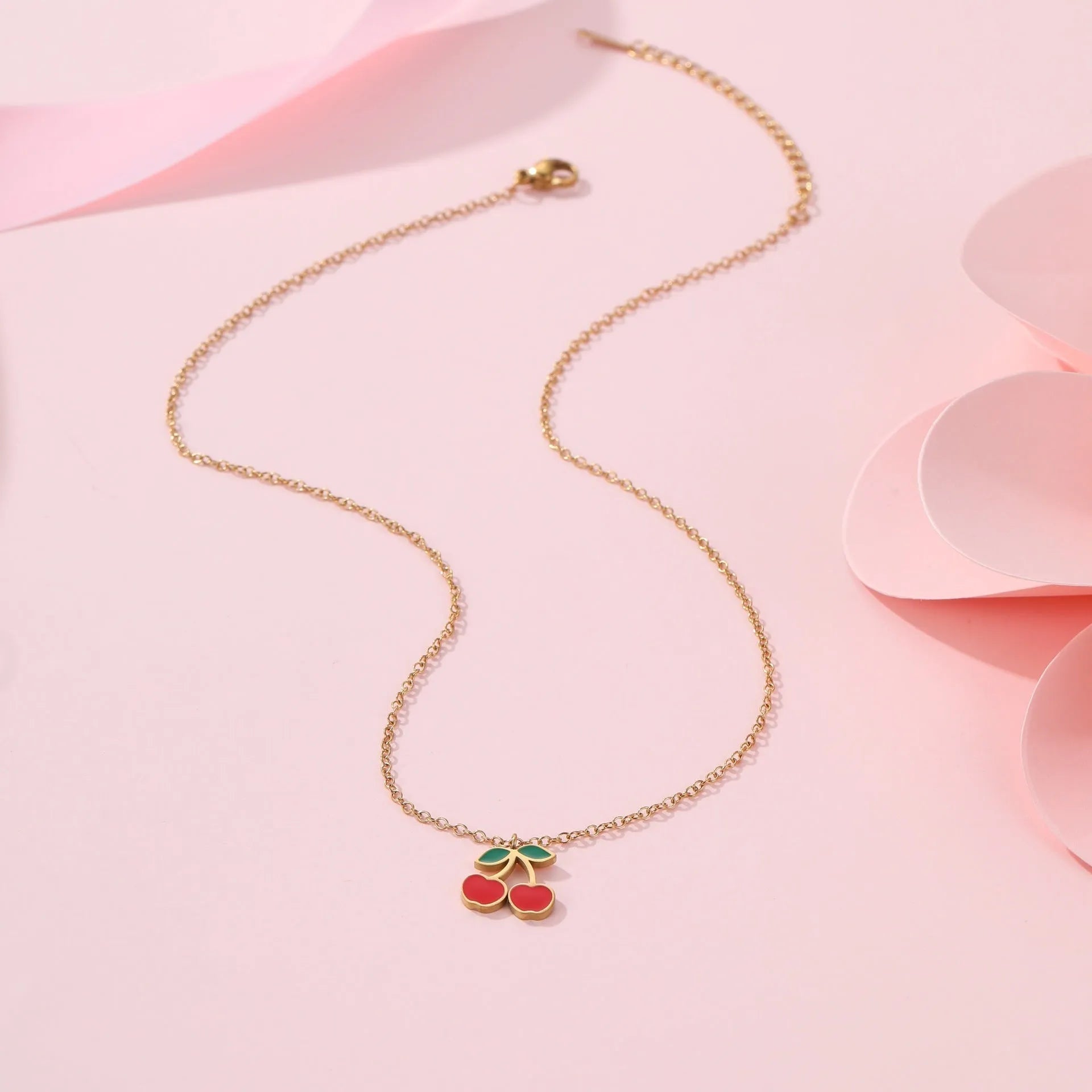 Four-piece cherry jewellery set showing necklace, bracelet, earrings, and ring with 18K electroplated finish