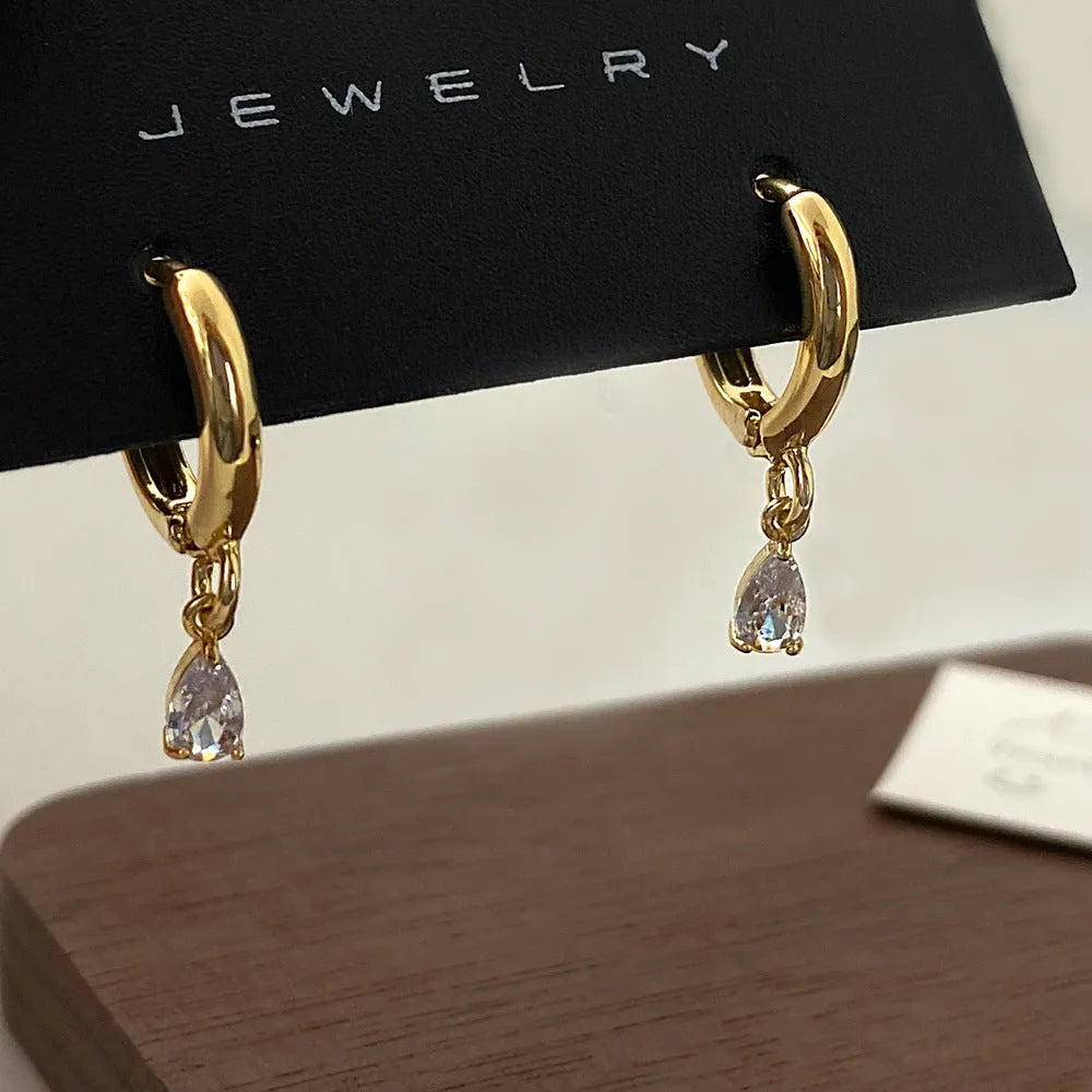 Zircon three-piece jewellery set with geometric meteor shower pendant necklace, matching earrings, and anklet.