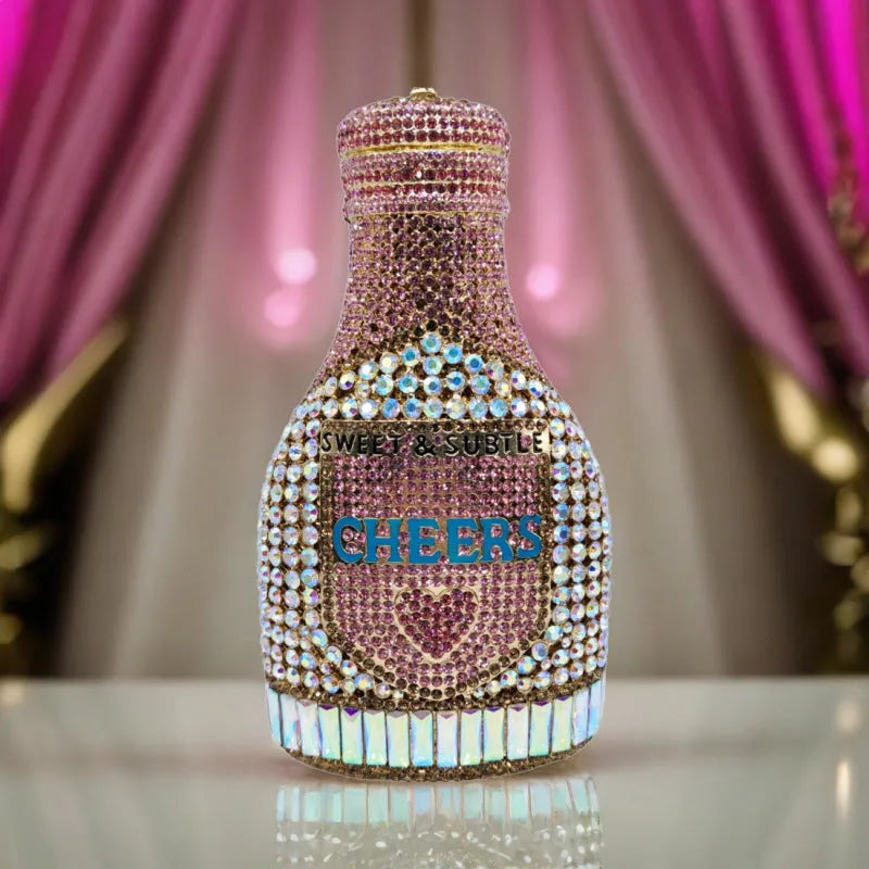 Gold champagne bottle shaped evening clutch with rhinestone decoration on black background