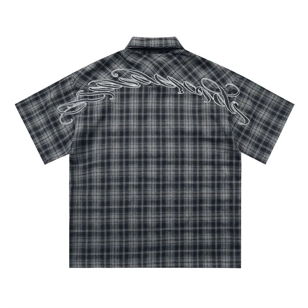 Men's black and brown plaid shirt with embroidered letter detail on chest, short sleeves, lapel collar