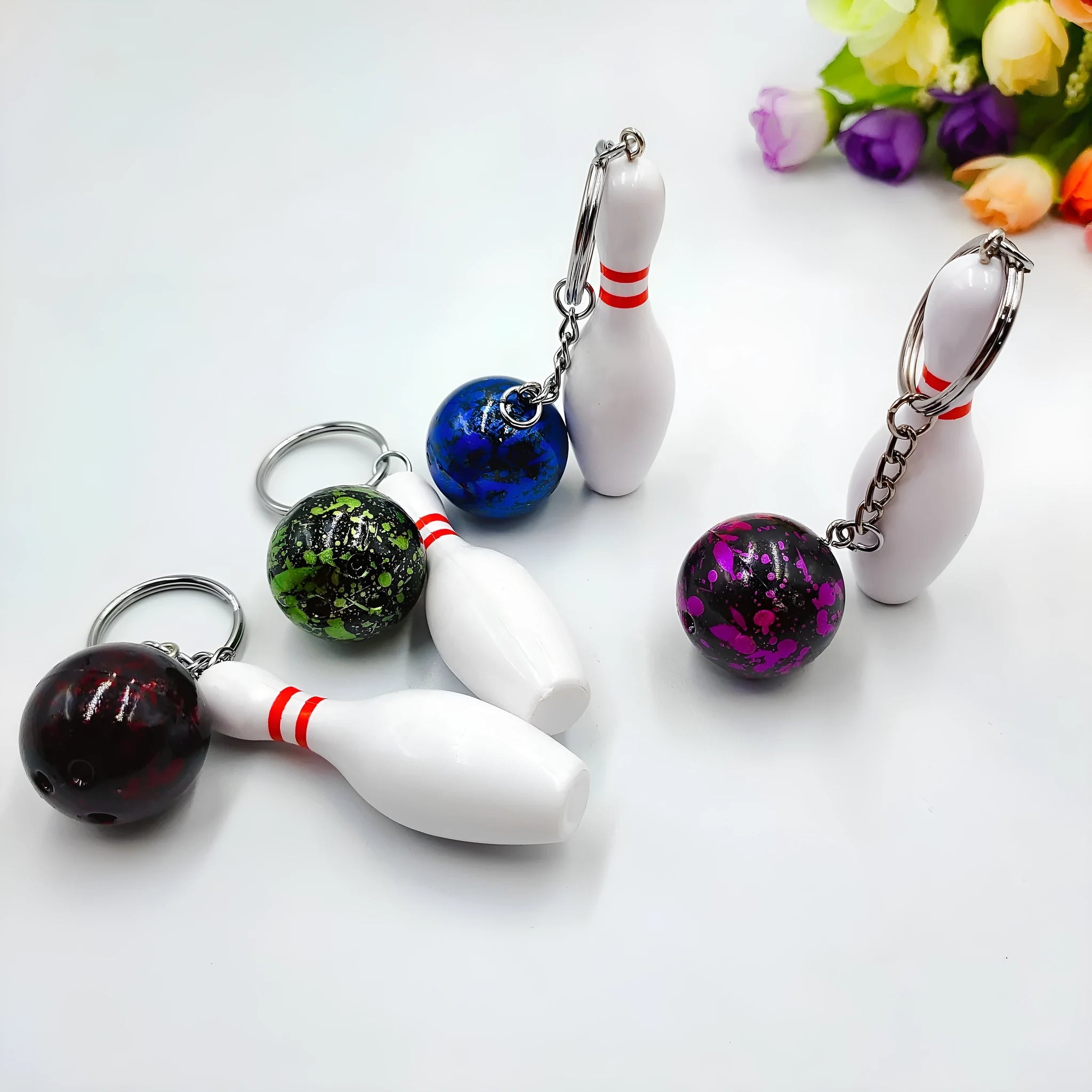 Mini simulation bowling ball keychain pendant in dark red, blue, purple, and green colour options.