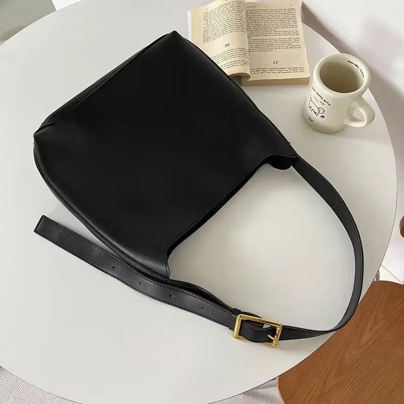 Two women's soft PU shoulder bags with swing thread detailing in black and brown colour options
