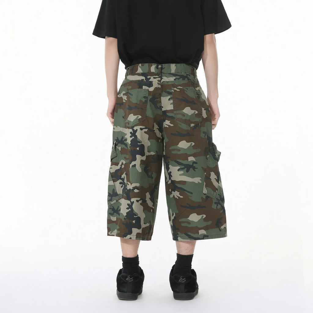 Men's cropped length camouflage cotton wide-leg jeans with large side pockets on a plain background.