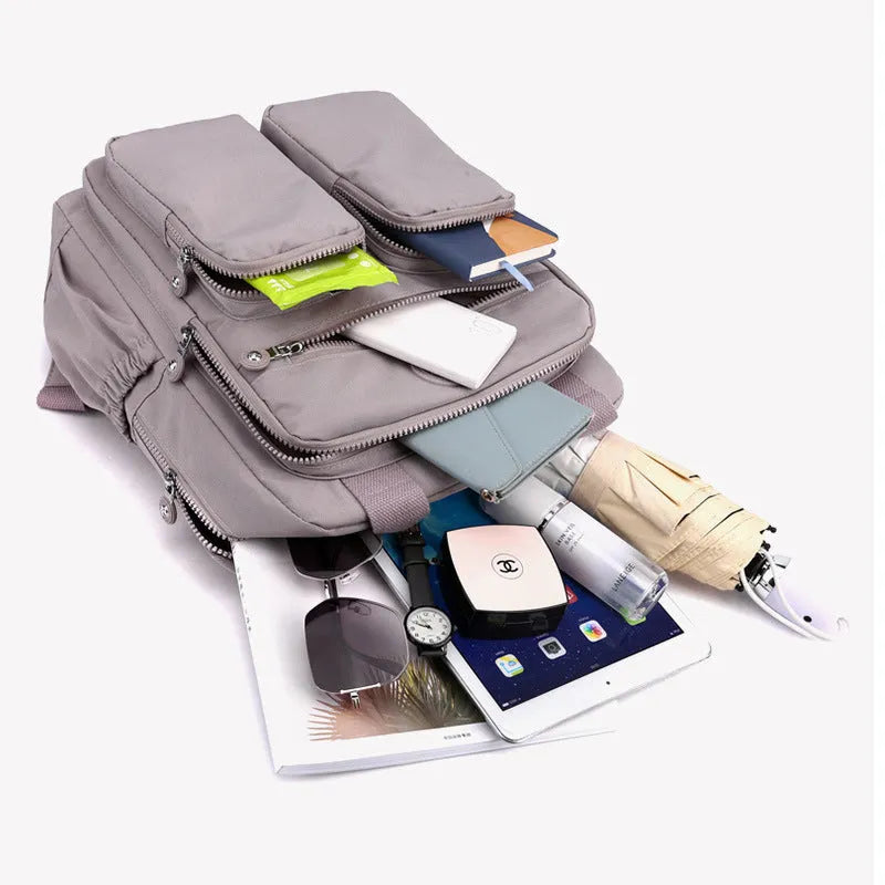 Waterproof nylon travel backpack in lotus root purple colour, showing multiple internal compartments and an external 3D pocket.
