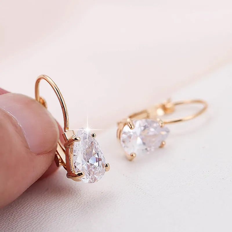A pair of women's drop-shaped copper earrings with gemstone inlay, shown in gold and platinum colour options.
