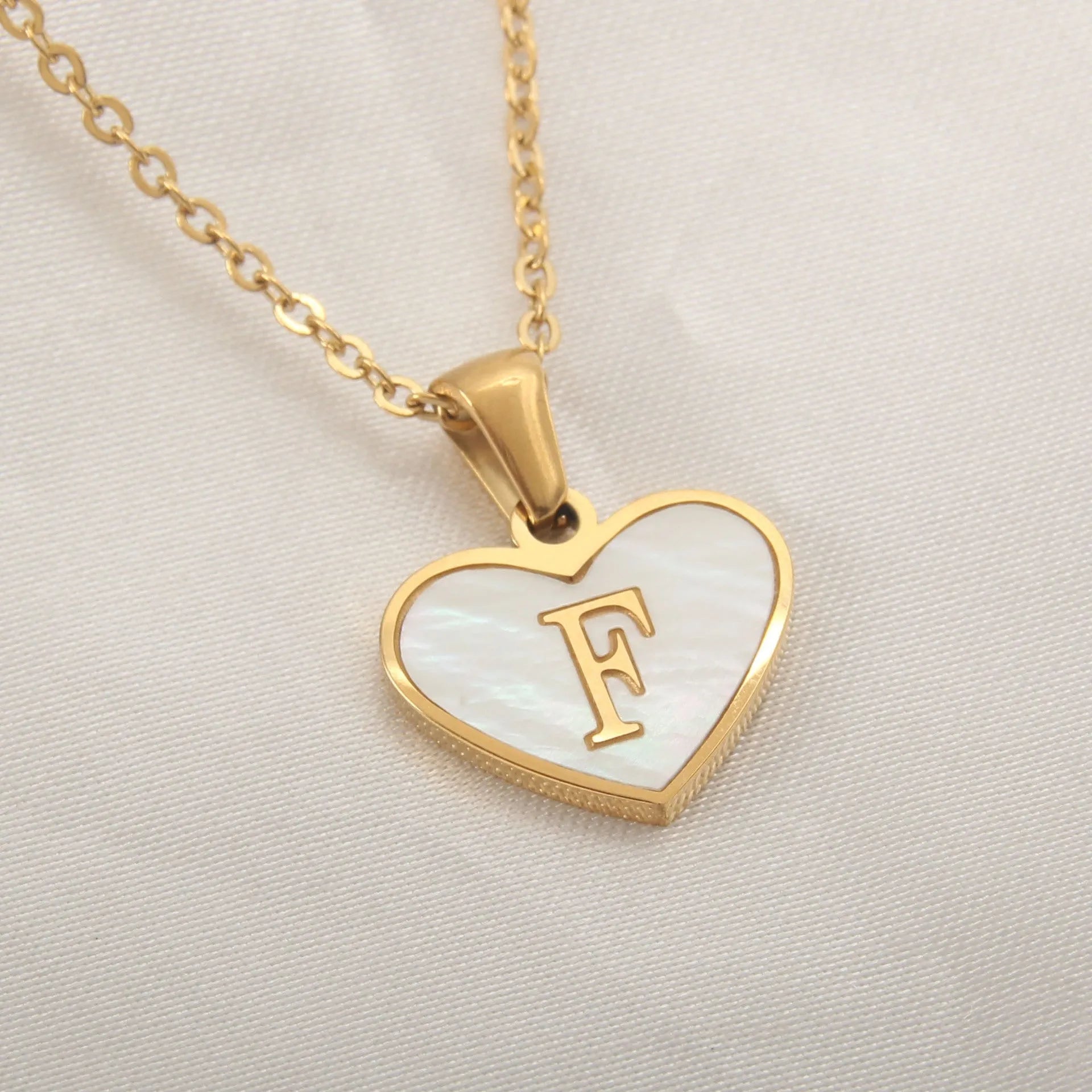 Gold plated chain necklace with a white shell heart-shaped pendant personalised with a single letter initial.