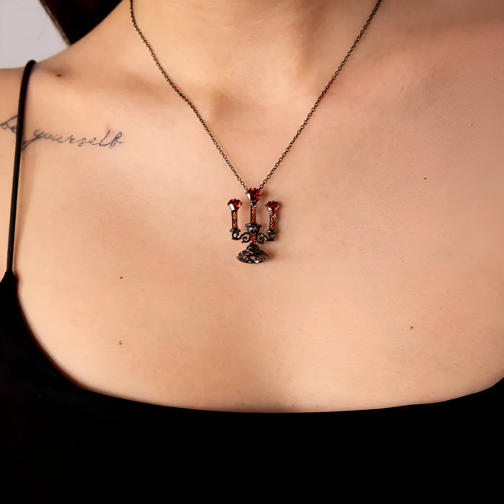 Women's silver Gothic necklace featuring a hollow candlestick pendant on a cross chain.