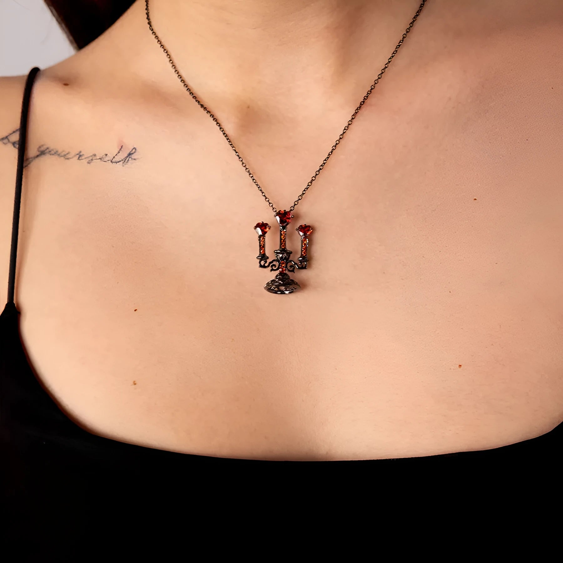 Women's silver Gothic necklace featuring a hollow candlestick pendant on a cross chain.