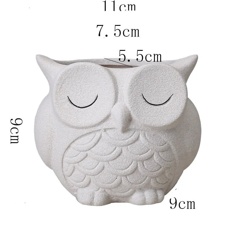 Handmade frosted ceramic owl succulent pot in pastel colour on a wooden surface.