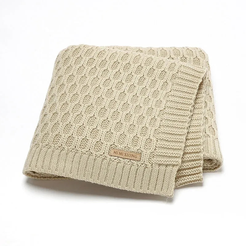 Solid colour infant hug blanket with three-dimensional lines, shown in one of five colour options.