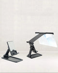 Black folding mobile phone screen amplifier with detachable holder next to an iPhone.