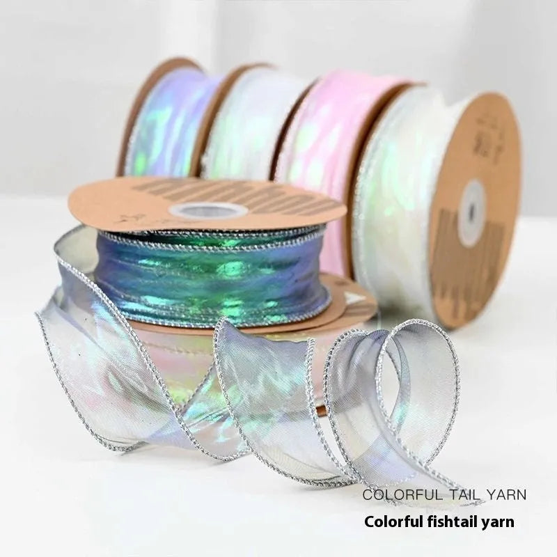 Roll of 4cm wide mesh fishtail yarn ribbon in colourful wave design for craft projects.