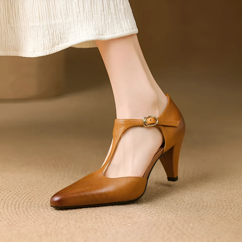 Brown retro women's sandals with T-strap, closed round toe, and a stout heel on a wooden background.