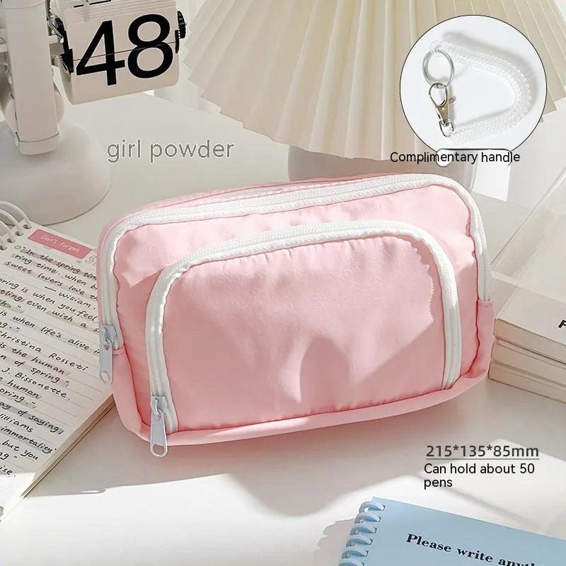 Double layer zippered pencil case in blue with an attached carry handle, showing two compartments.