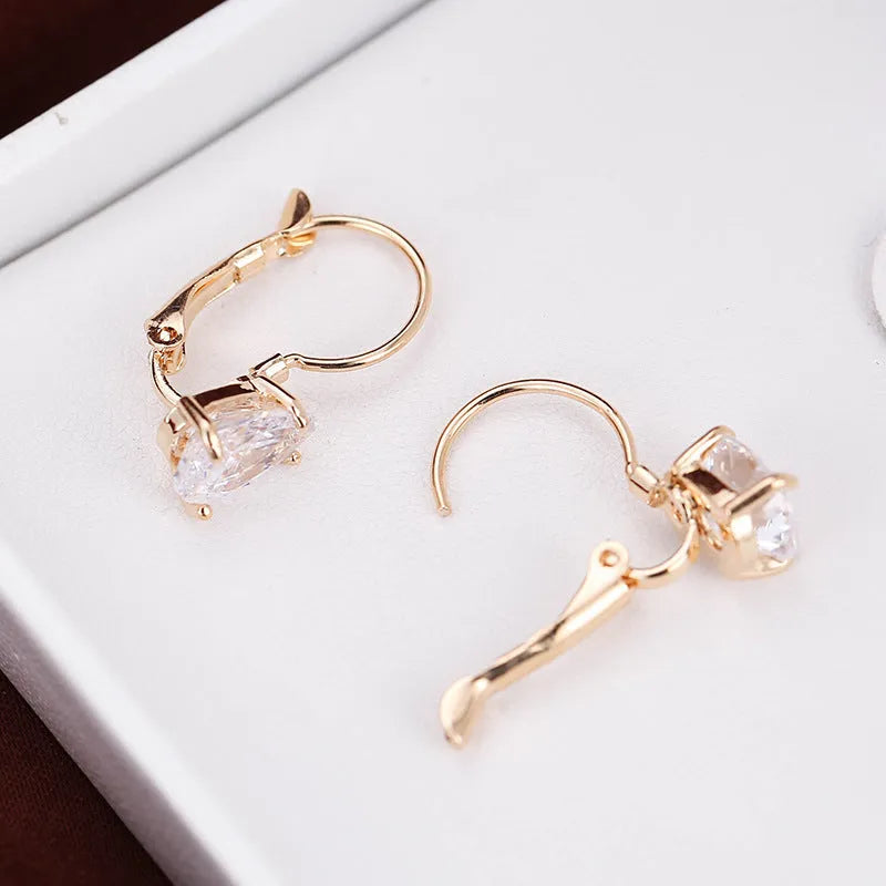 A pair of women's drop-shaped copper earrings with gemstone inlay, shown in gold and platinum colour options.