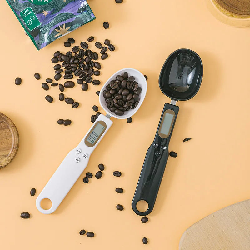 White digital spoon scale with LCD display measuring 500g capacity on a kitchen surface