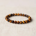 Single tigereye bead ethnic Buddha bracelet on wrist, showing simple rosary style.
