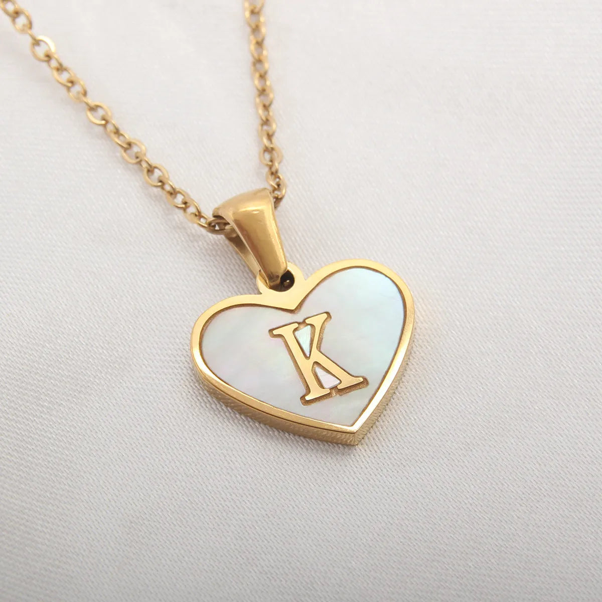 Gold plated chain necklace with a white shell heart-shaped pendant personalised with a single letter initial.