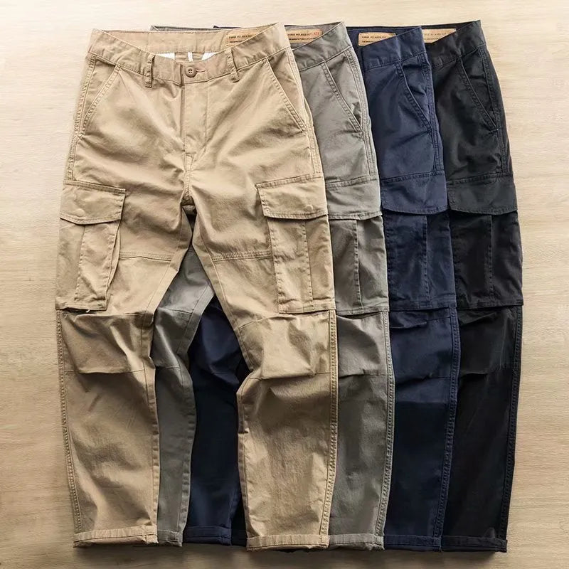 Men's solid colour cotton trousers with multiple pockets in a cropped length, shown in khaki, grey, black, and blue.