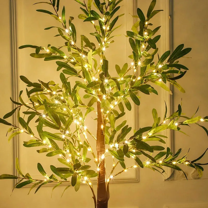 Tall 1.8 metre simulation olive leaf tree lamp with warm white LEDs lit, showing abstract trunk design.