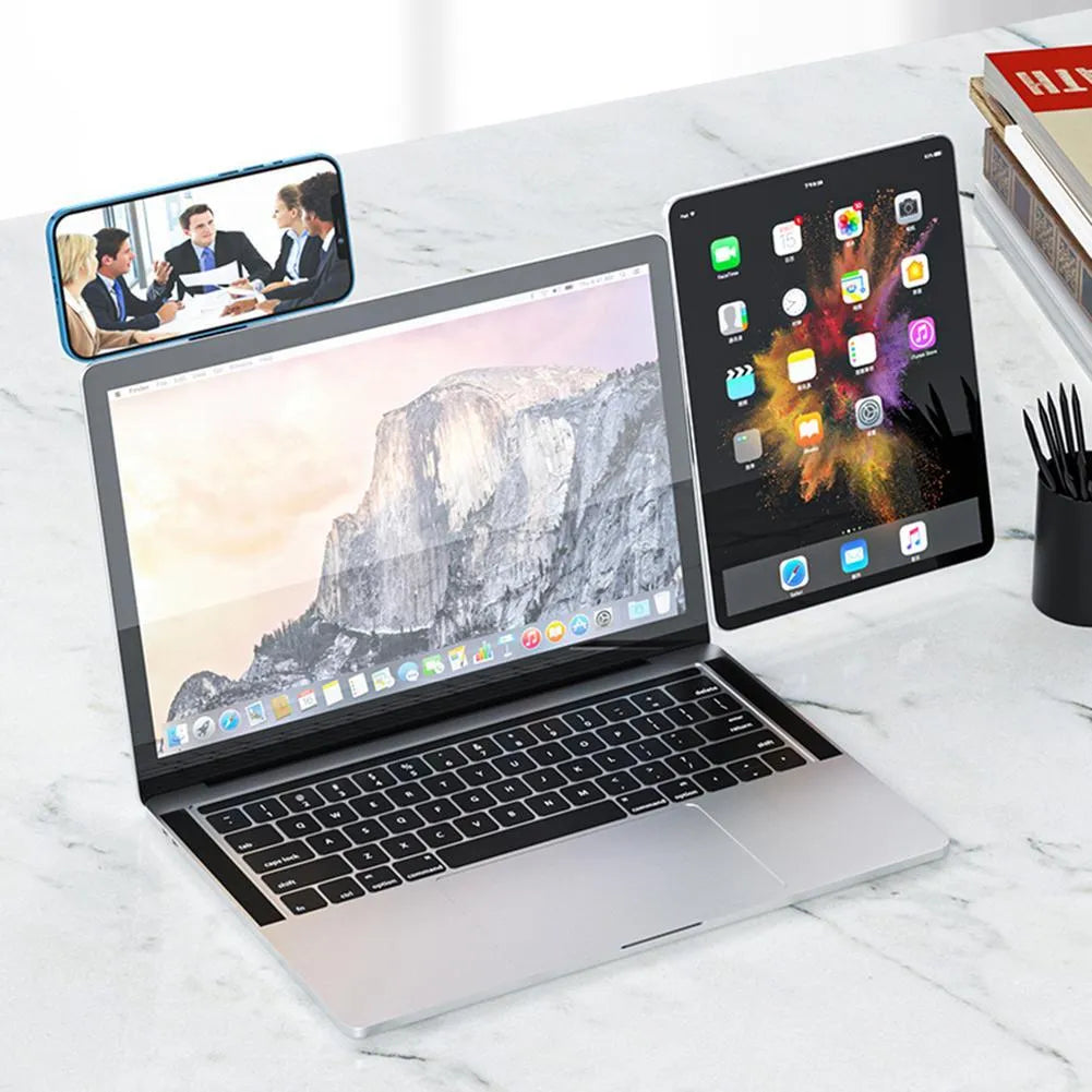 Black aluminum laptop phone holder clipped to a monitor, holding a smartphone and with headphones hanging from the hook.