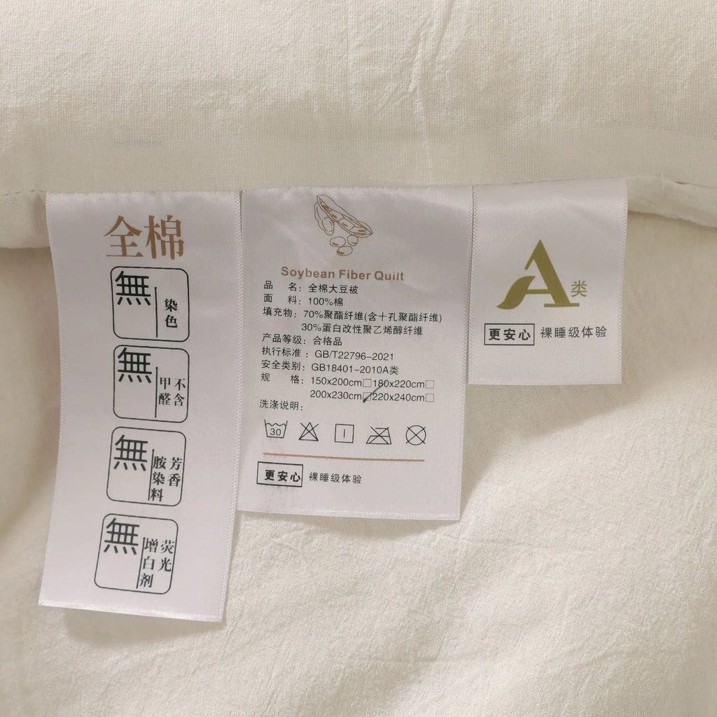 A pure cotton soybean fibre quilt in grey, shown folded, with details of its twill weave and size label.