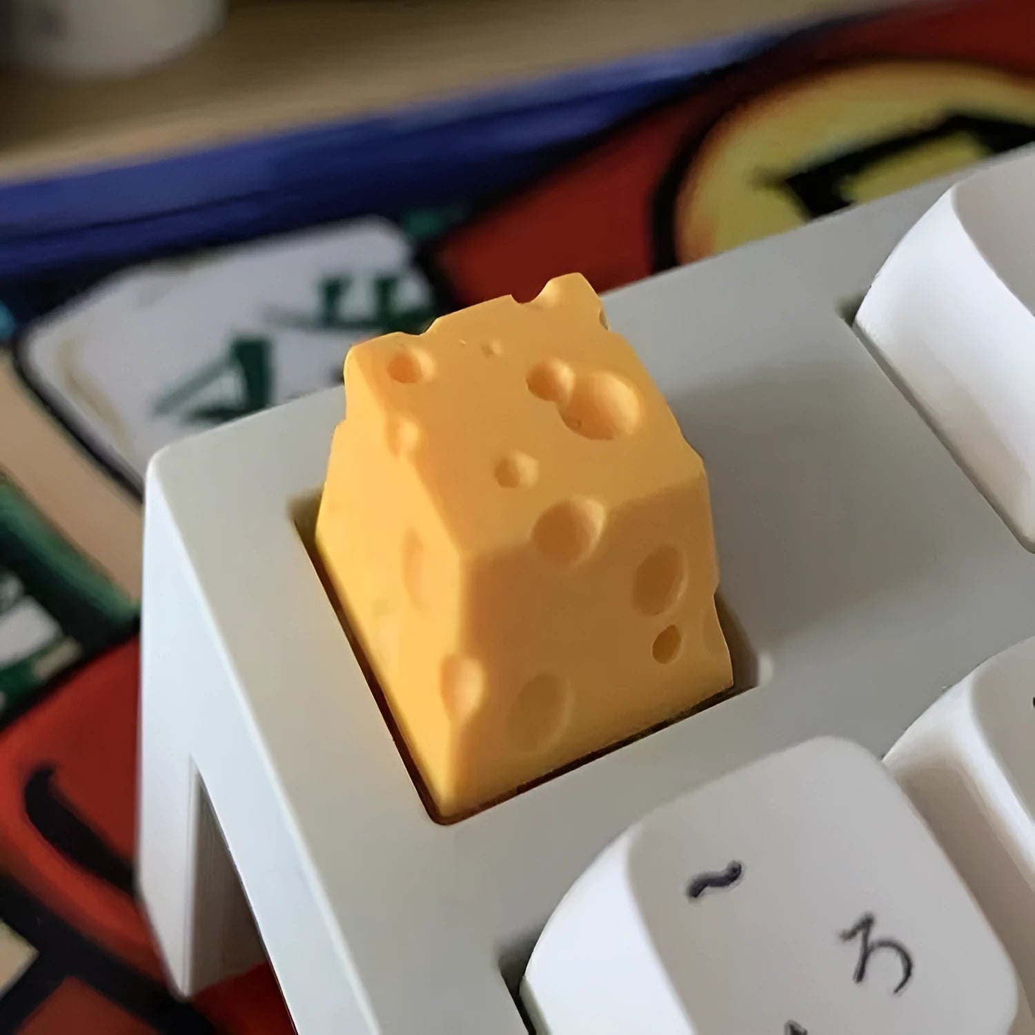 Close-up of a yellow resin cheese-shaped keycap for a mechanical keyboard.