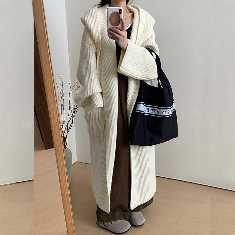 Loose grey hooded cardigan coat with raglan sleeves shown on a hanger.