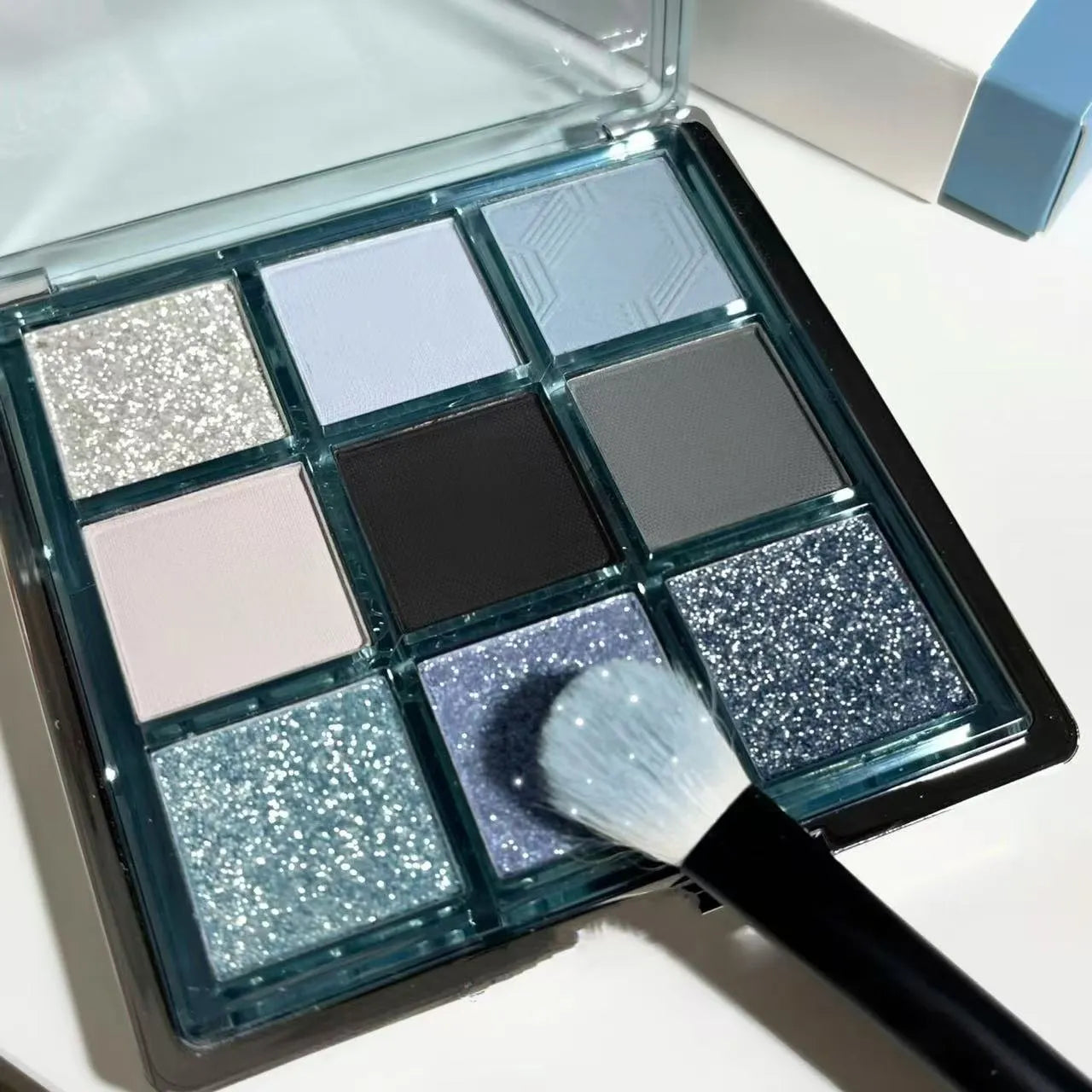 MUGELEEN nine-colour eye shadow palette showing blue smoked colours with matte and shimmer finishes