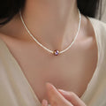Pink purple freshwater pearl pendant necklace with U-shaped geometric design on a woman
