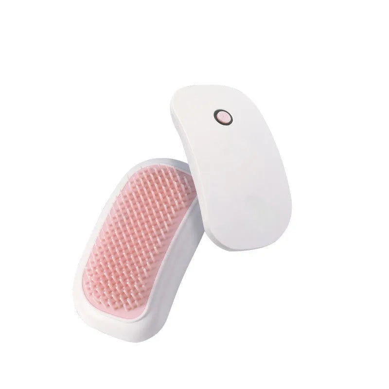 Pink handheld electric pet grooming brush with TPE comb teeth on a white background