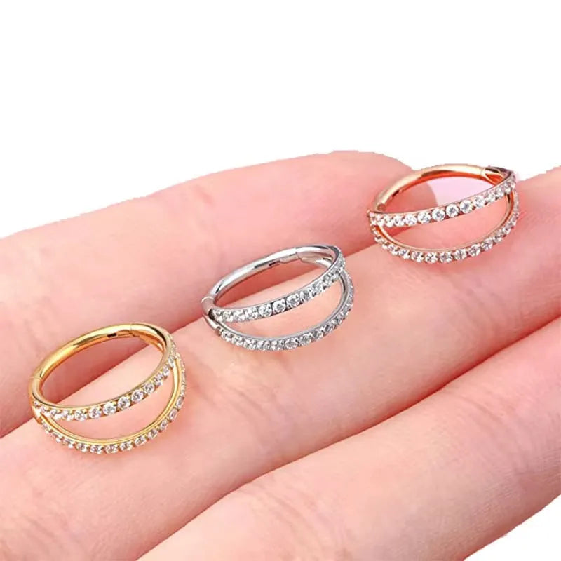 G23 titanium alloy nose ring with zircon accent in steel colour on a grey background.