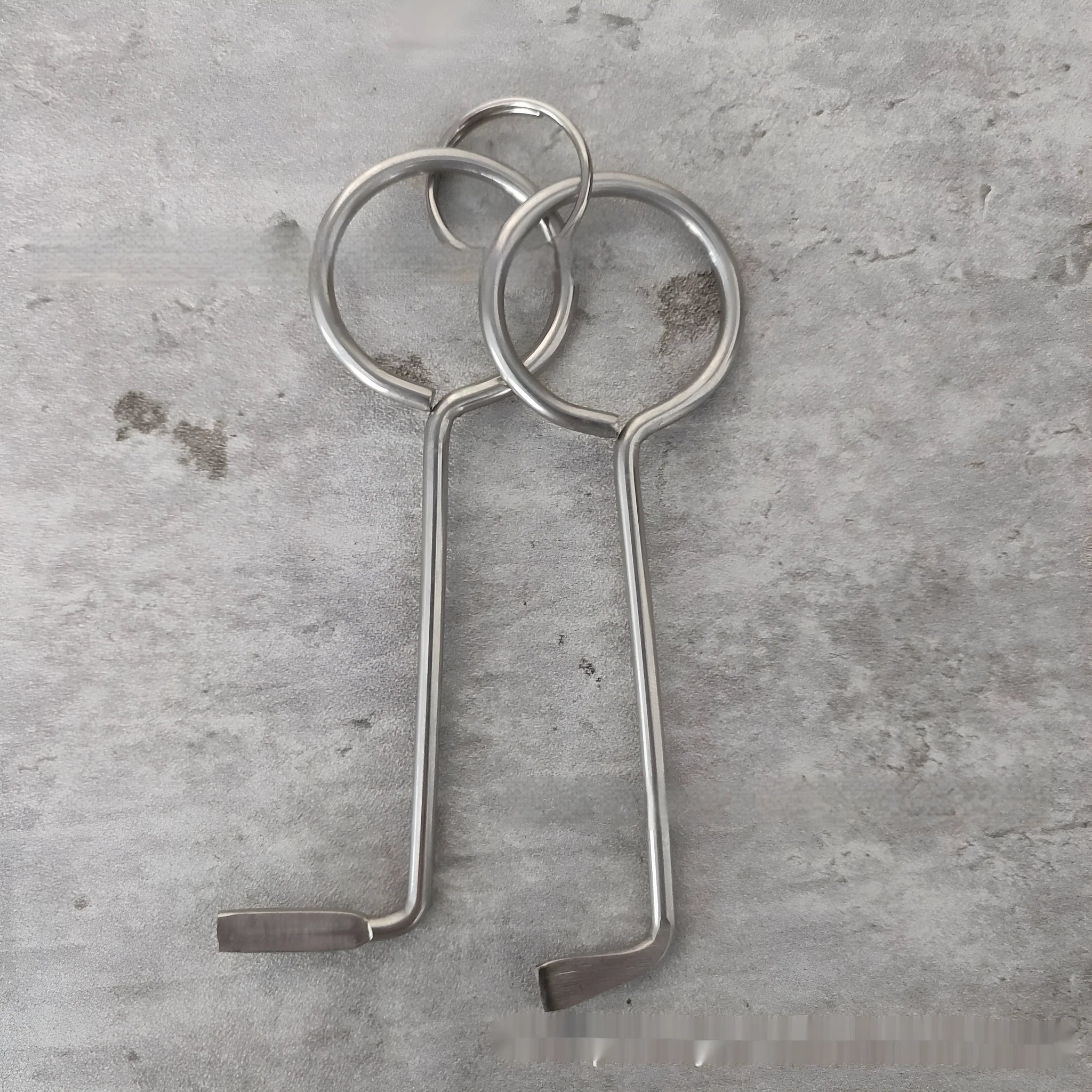 Two silver alloy universal wrench tools side by side on a surface.