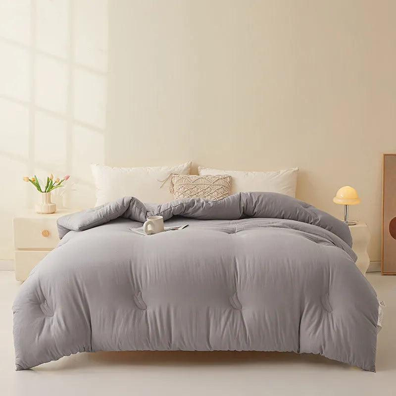 Soybean fibre quilt with pure cotton cover in grey, shown on a bed.
