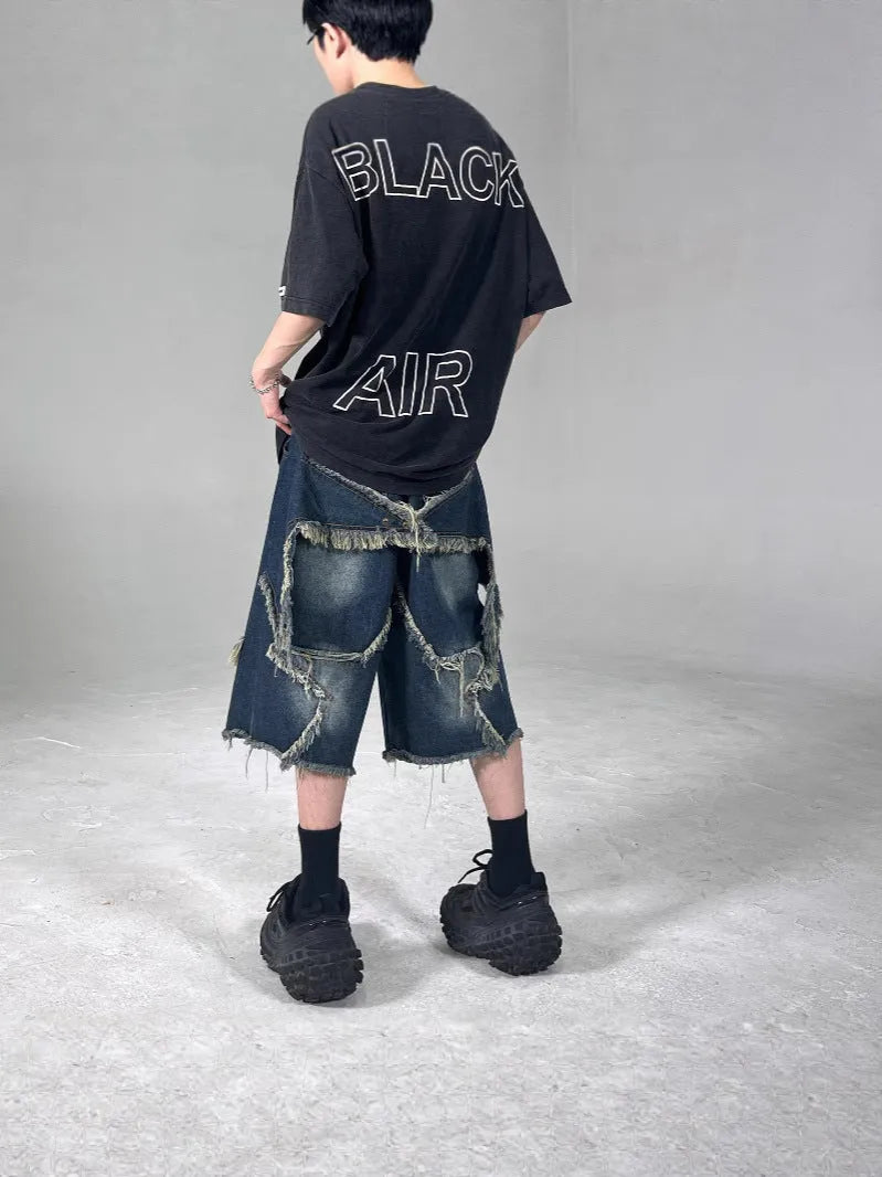 Blue denim shorts with distressed five-pointed star detailing and frayed hem, loose fit retro style