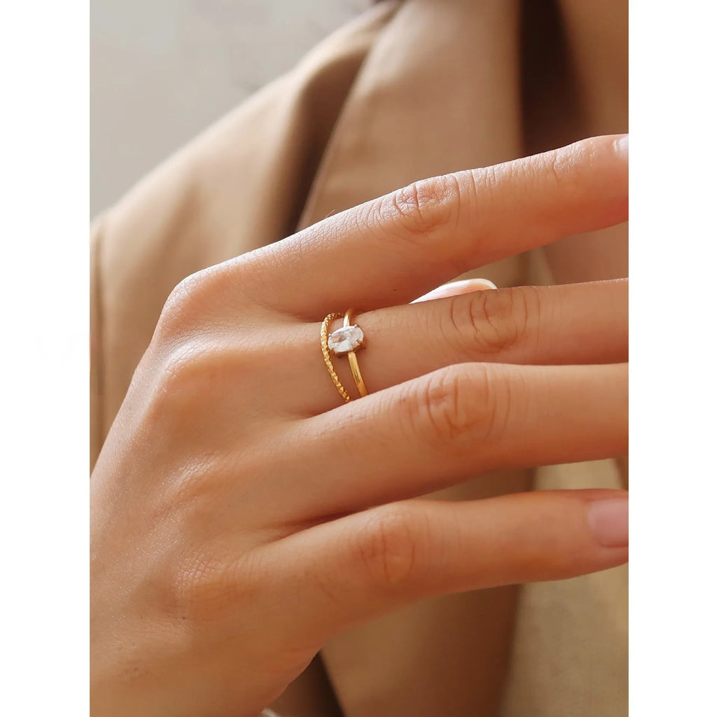 Golden love heart and oval stainless steel ring for women on a white background.