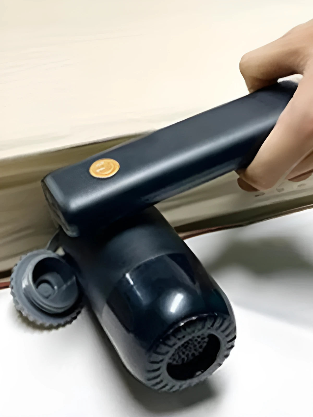 Black car charging vacuum cleaner with crevice nozzle and brush nozzle on a white background