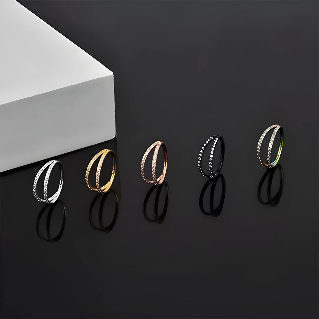 G23 titanium alloy nose ring with zircon accent in steel colour on a grey background.