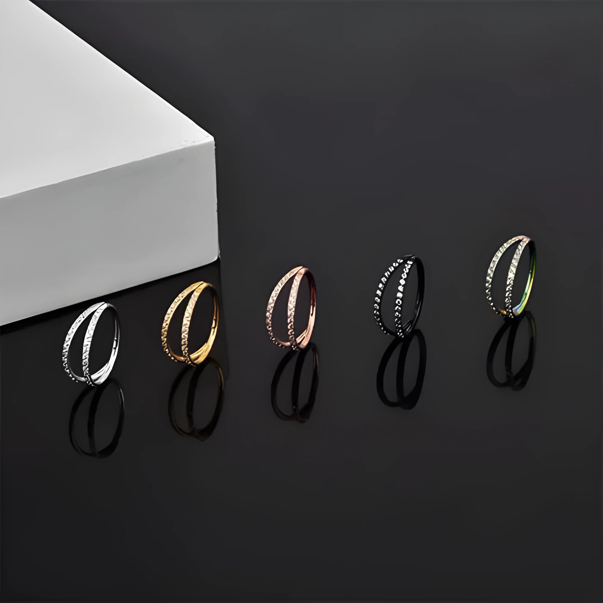 G23 titanium alloy nose ring with zircon accent in steel colour on a grey background.