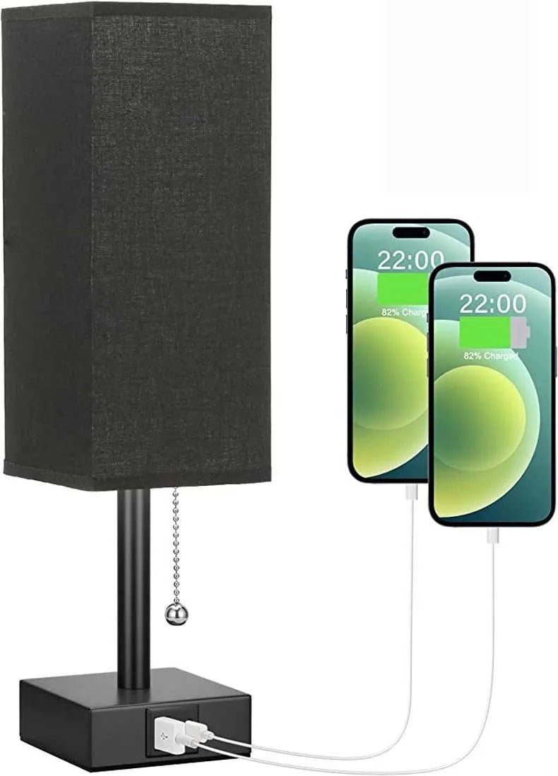 Small bedside table lamp with beige fabric shade and black base on a nightstand