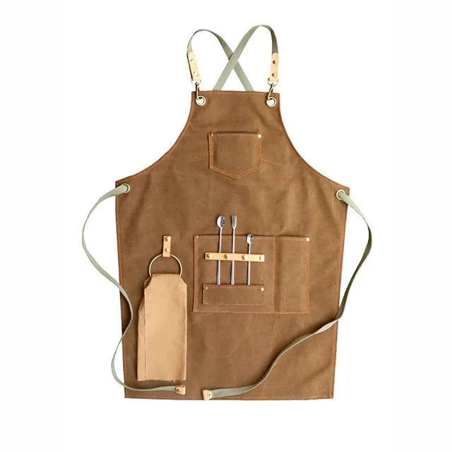 Canvas apron with cross-back straps in camel colour.